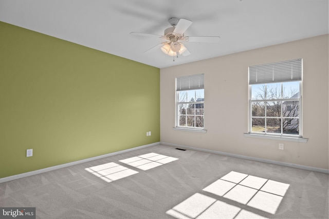 unfurnished room with a ceiling fan, carpet flooring, baseboards, and visible vents