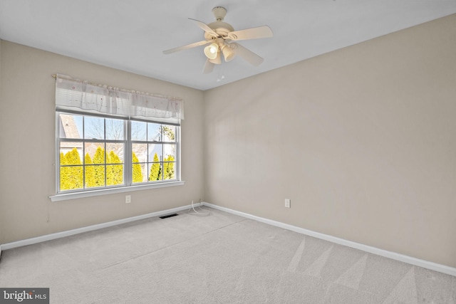 spare room with visible vents, ceiling fan, baseboards, and carpet floors