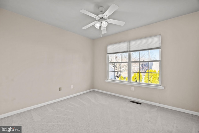 spare room with visible vents, baseboards, a ceiling fan, and carpet flooring