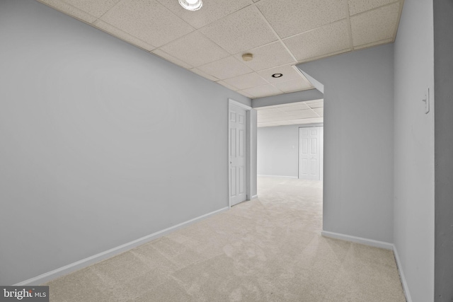 unfurnished room featuring a drop ceiling, baseboards, and carpet floors