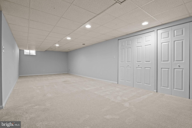 below grade area with recessed lighting, a paneled ceiling, baseboards, and carpet flooring