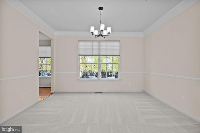 empty room featuring a chandelier, baseboards, ornamental molding, and carpet flooring