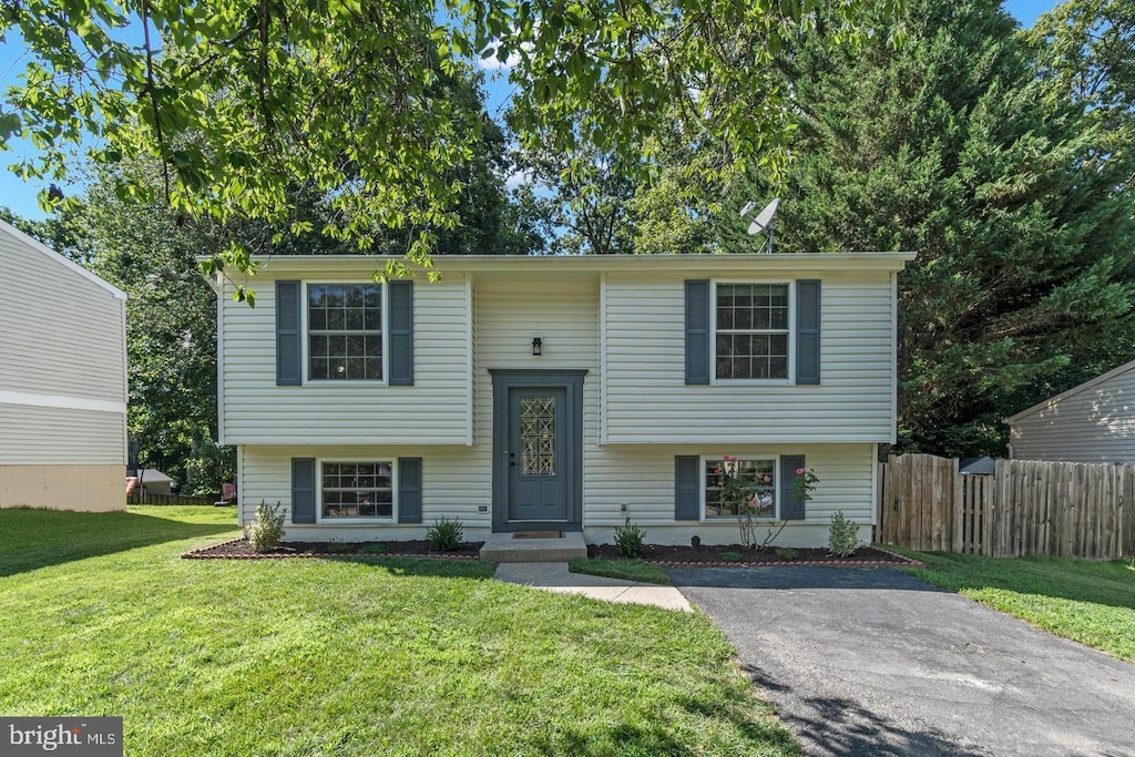 split foyer home featuring a front yard and fence