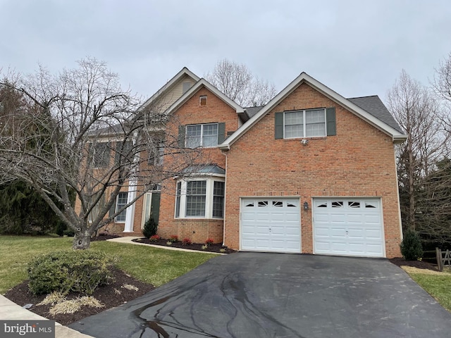 traditional-style home featuring aphalt driveway, a garage, brick siding, and a front lawn