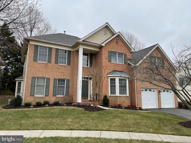 view of front of home featuring driveway, brick siding, an attached garage, and a front yard