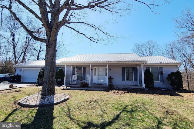 ranch-style home featuring a front lawn, covered porch, metal roof, driveway, and an attached garage