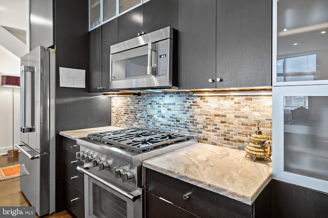 kitchen featuring tasteful backsplash, appliances with stainless steel finishes, and dark cabinets