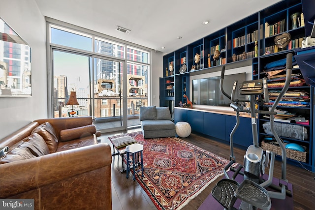 living room featuring visible vents, floor to ceiling windows, and wood finished floors