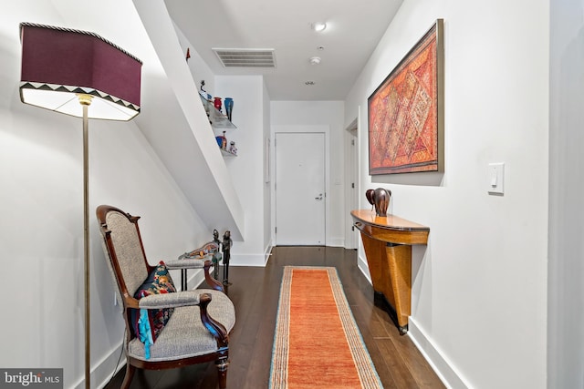 hallway featuring dark wood-style floors, visible vents, and baseboards