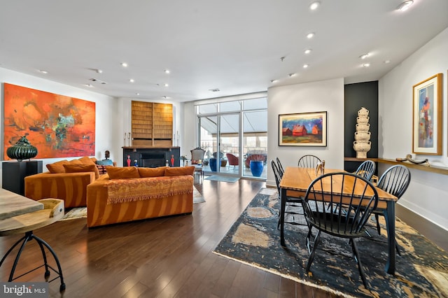 dining area with floor to ceiling windows, recessed lighting, wood-type flooring, a fireplace, and baseboards