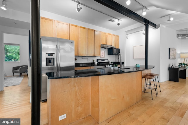 kitchen featuring appliances with stainless steel finishes, track lighting, a sink, light wood finished floors, and visible vents