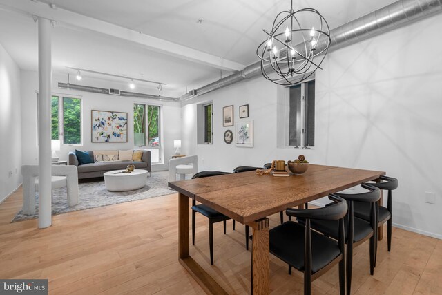dining space with rail lighting, a chandelier, visible vents, and light wood-style floors