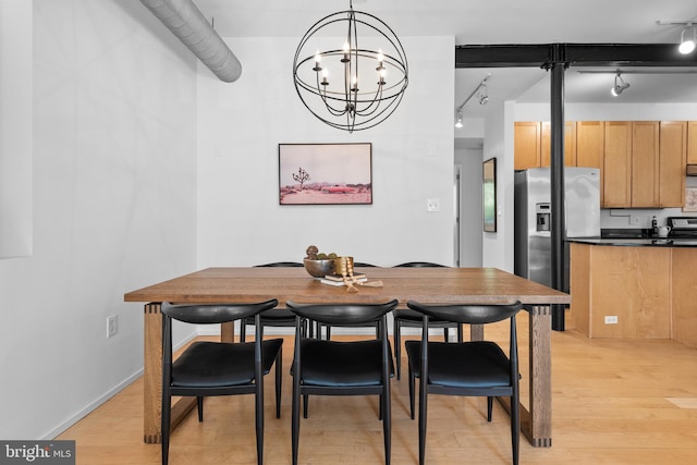 dining space featuring a notable chandelier, track lighting, and light wood finished floors