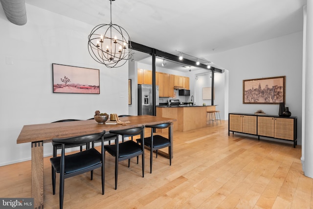 dining space featuring light wood-type flooring and a chandelier