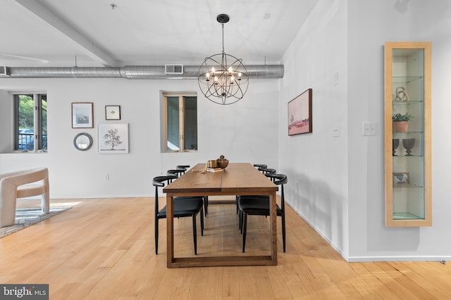 dining space with baseboards, a notable chandelier, light wood finished floors, and visible vents