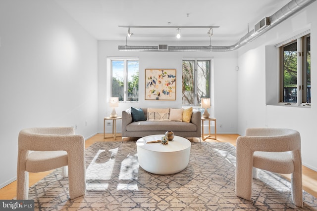 living room with baseboards, visible vents, and a healthy amount of sunlight