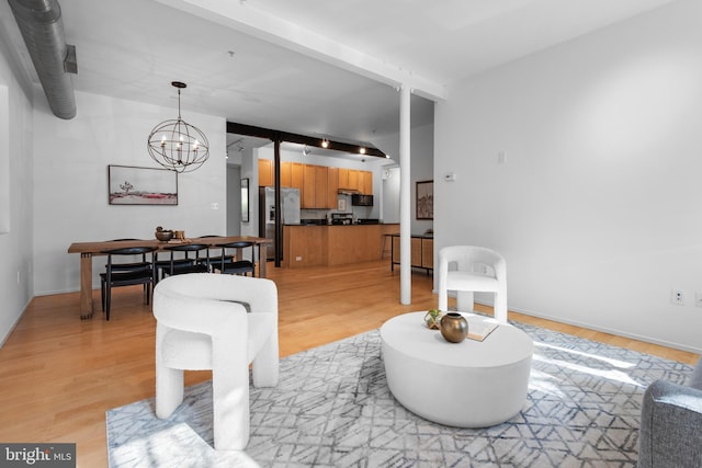living area with an inviting chandelier and light wood-type flooring