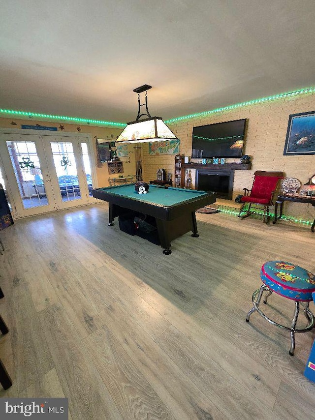 rec room with french doors, billiards, wood finished floors, and a fireplace