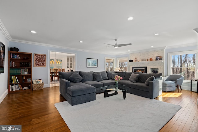 living room with recessed lighting, a fireplace, dark wood-type flooring, and crown molding