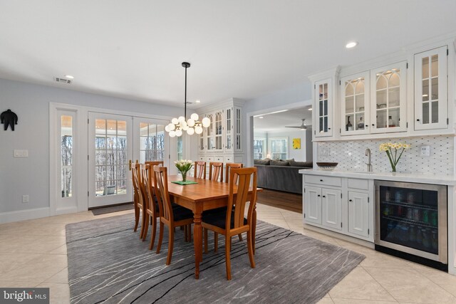 dining room featuring recessed lighting, french doors, wine cooler, light tile patterned floors, and baseboards