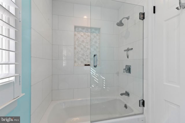 full bath featuring bath / shower combo with glass door