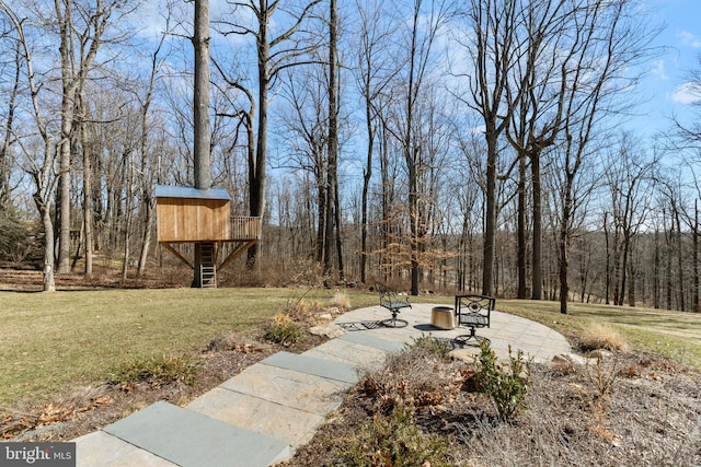 view of yard with a wooded view and stairs