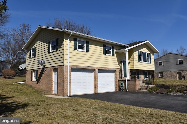 view of front of property featuring brick siding, an attached garage, aphalt driveway, and a front lawn