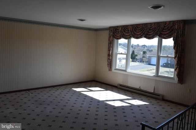 spare room featuring baseboards, visible vents, and a baseboard radiator