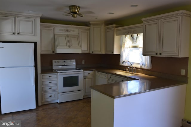 kitchen featuring white appliances, a ceiling fan, a peninsula, a sink, and dark countertops