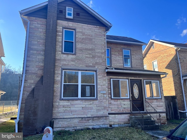 back of property with stone siding and entry steps