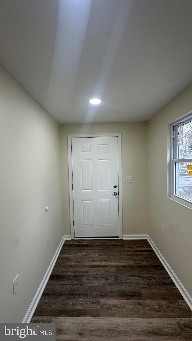 doorway to outside with dark wood-type flooring and baseboards