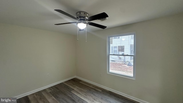 spare room with dark wood finished floors, baseboards, and a wealth of natural light