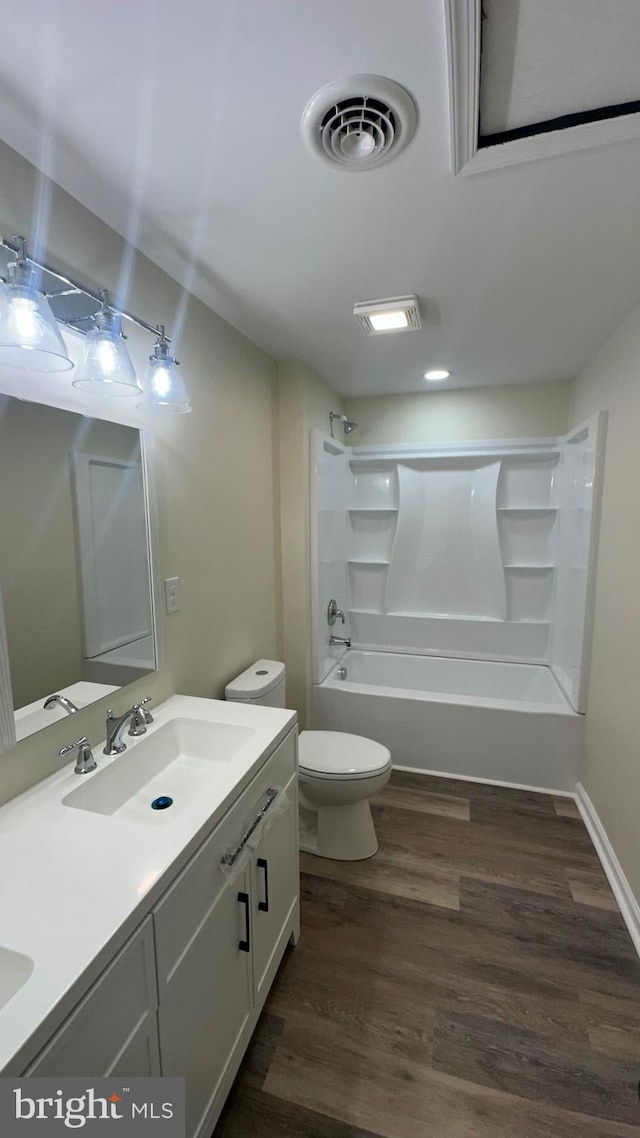 full bathroom with visible vents, toilet, shower / tub combination, wood finished floors, and a sink