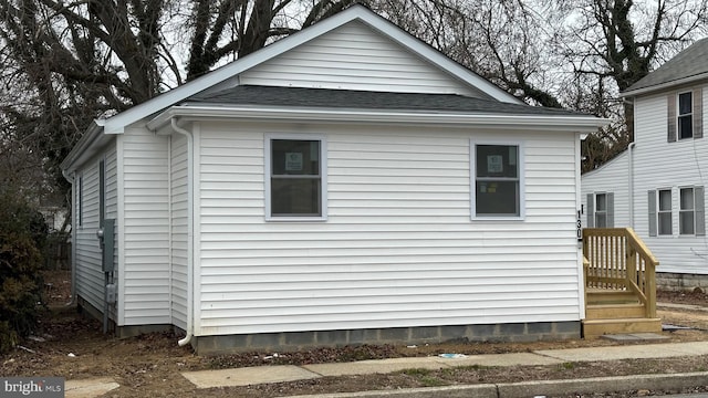 view of property exterior with roof with shingles