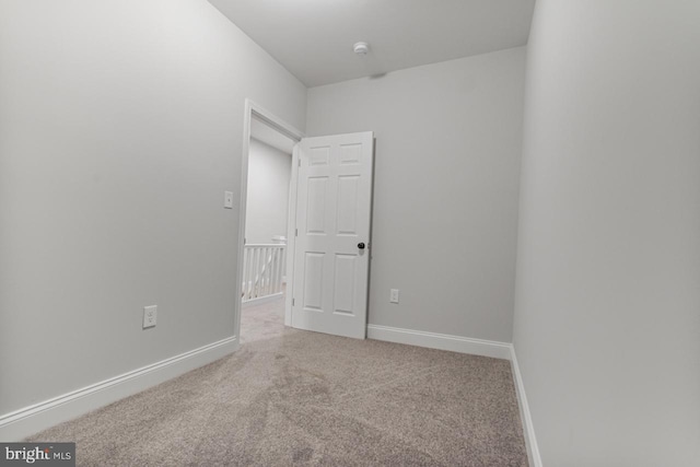 empty room featuring carpet flooring and baseboards