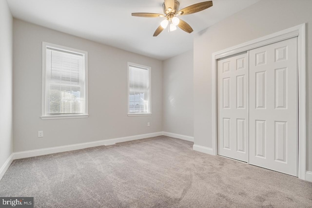 unfurnished bedroom featuring a closet, a ceiling fan, baseboards, and carpet floors