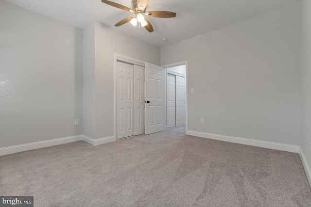 unfurnished bedroom with a closet, carpet flooring, a ceiling fan, and baseboards