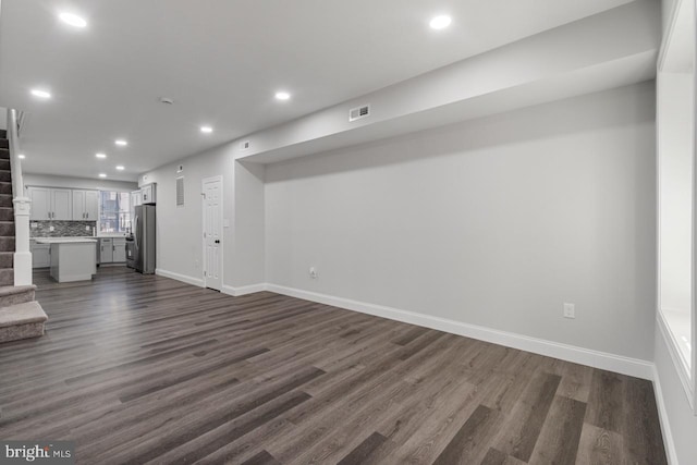 unfurnished living room featuring stairway, recessed lighting, dark wood-style floors, and visible vents