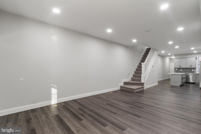 unfurnished living room with recessed lighting, stairs, baseboards, and dark wood-style flooring