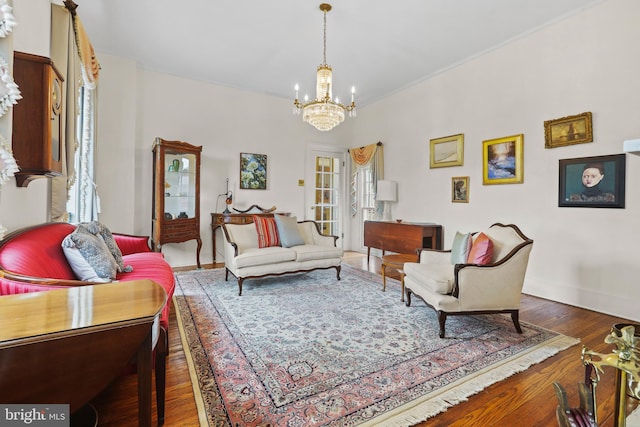 living area with wood finished floors, baseboards, and a chandelier