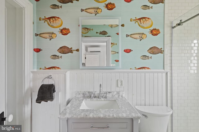 full bath with toilet, wainscoting, vanity, and a wall mounted AC