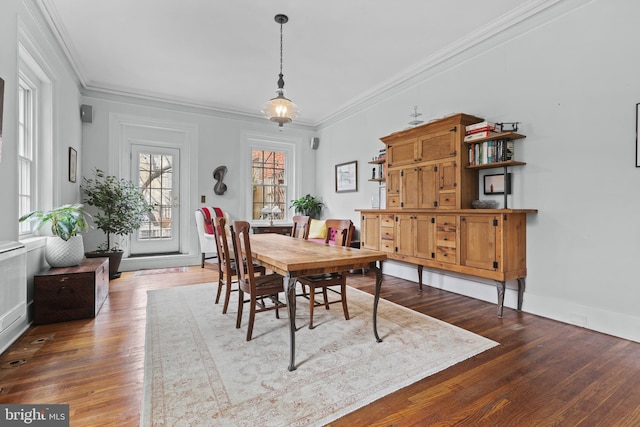 dining space with crown molding, baseboards, and hardwood / wood-style floors