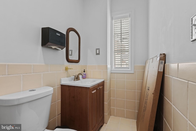 bathroom with vanity, tile walls, toilet, and a wainscoted wall