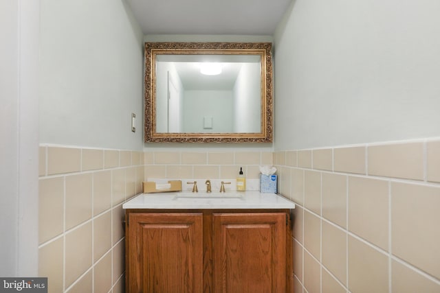 bathroom featuring wainscoting, tile walls, and vanity