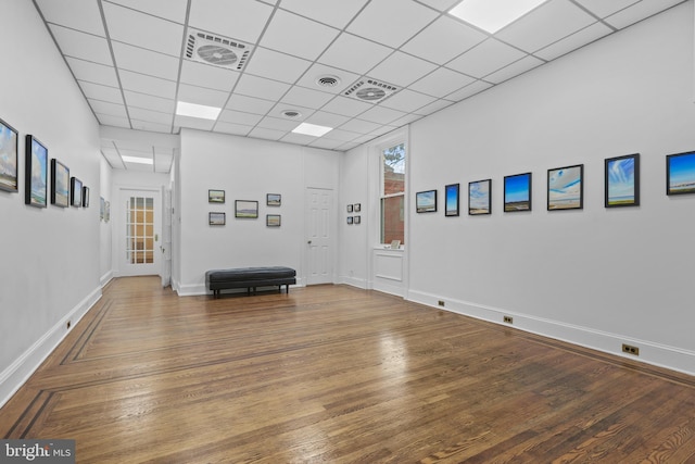 interior space with visible vents, wood finished floors, baseboards, and a paneled ceiling