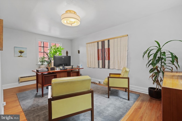 office area with wood finished floors, baseboards, and baseboard heating