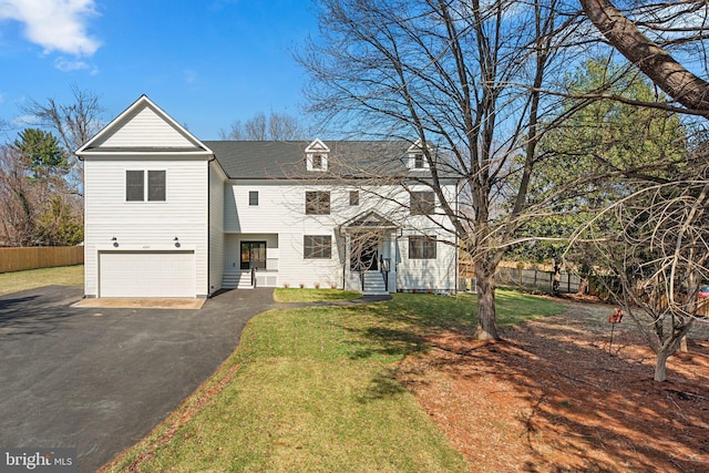 view of front of home with a front yard, an attached garage, fence, and driveway