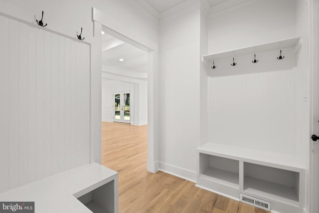 mudroom with crown molding, baseboards, visible vents, and light wood-type flooring