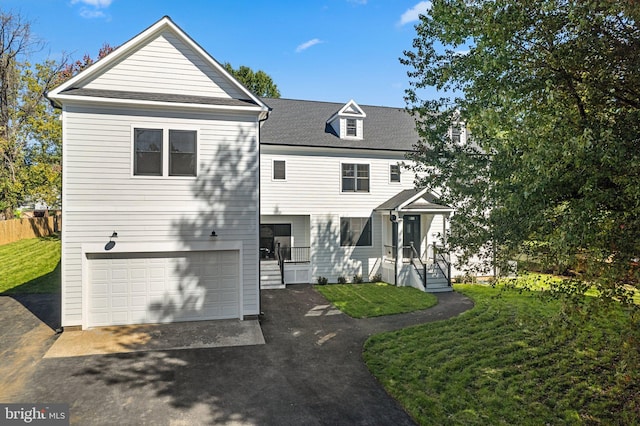 view of front of home featuring a garage, driveway, and a front yard