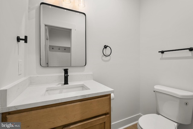 bathroom featuring vanity, toilet, and baseboards